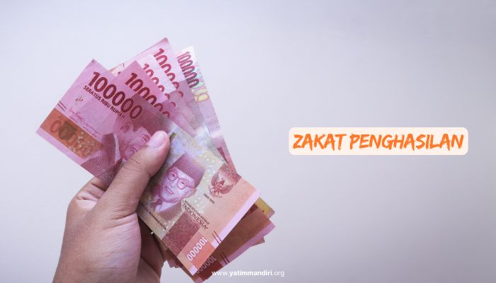 5 uang dengan nominal Rp100.000 sedang dipegang menggunakan satu tangan